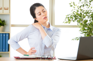 woman with shoulder pain desk laptop